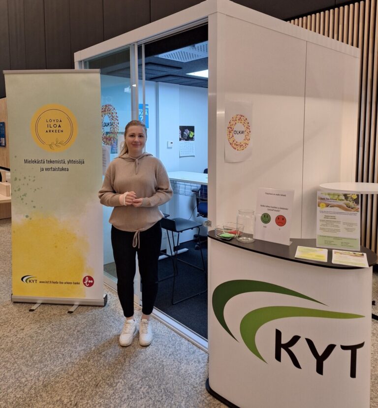 Hanketyöntekijä seisoo esittelypisteellä sairaalan aulakäytävällä.